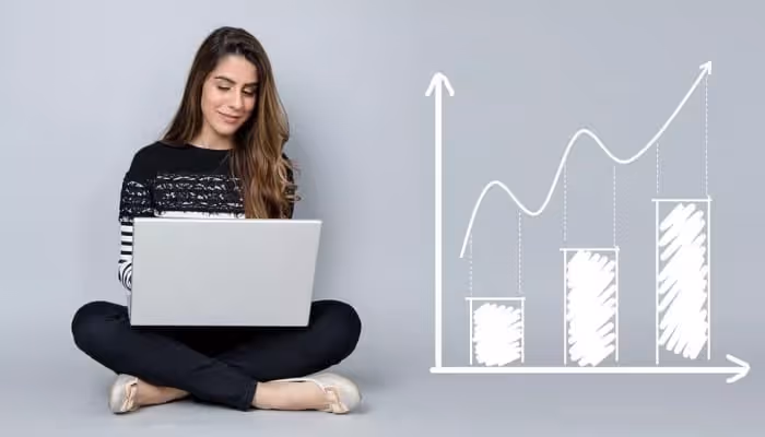 Woman using a laptop beside a hand-drawn growth chart