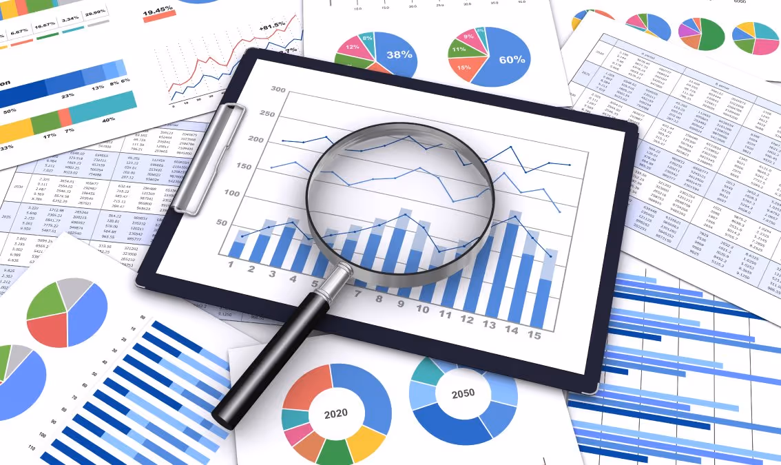 Magnifying glass placed over financial charts and graphs for data analysis