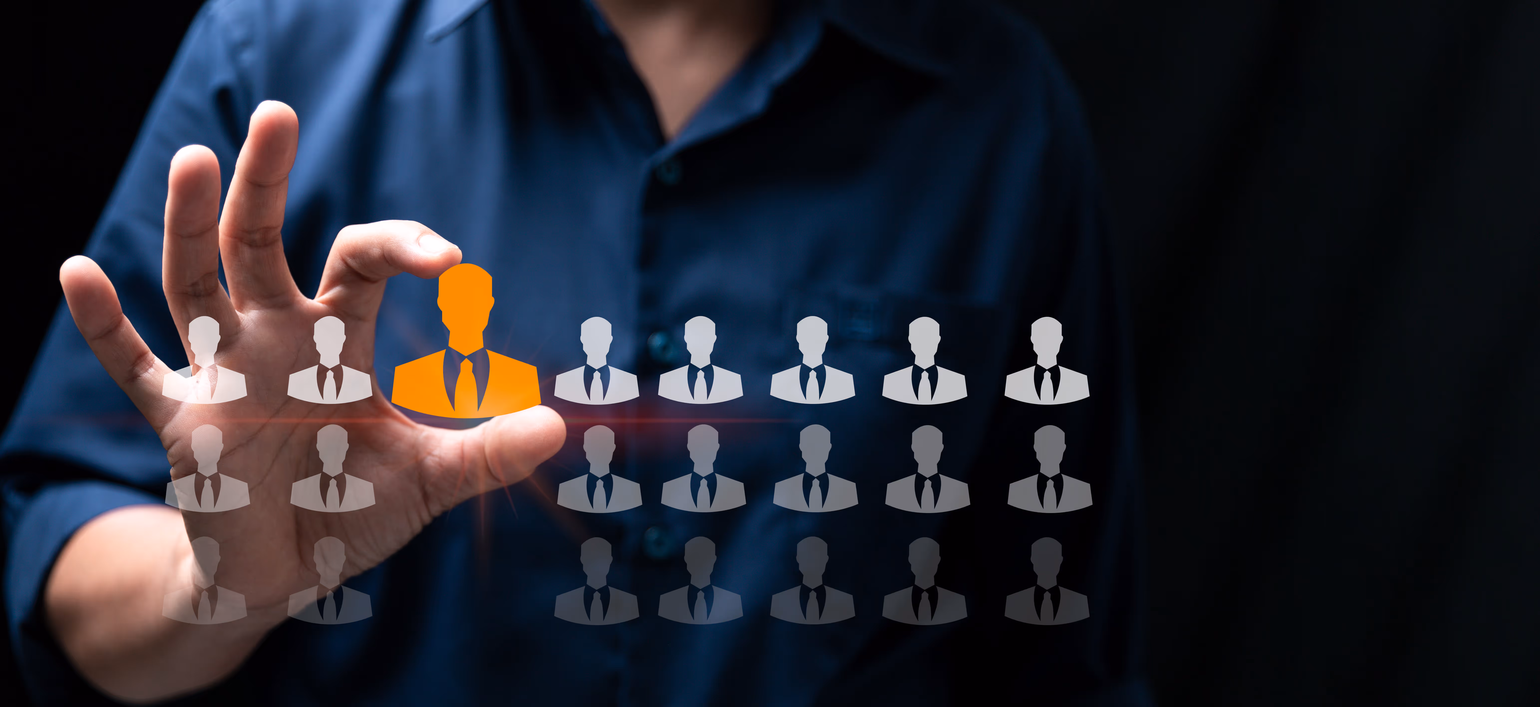 Hand selecting a highlighted candidate icon among multiple silhouettes, symbolizing talent selection