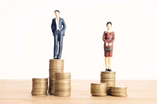 Gender pay gap concept showing male and female figures standing on uneven coin stacks, illustrating income inequality