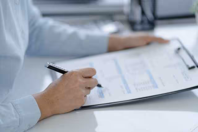 Person reviewing compensation data on a clipboard in a bright office setting