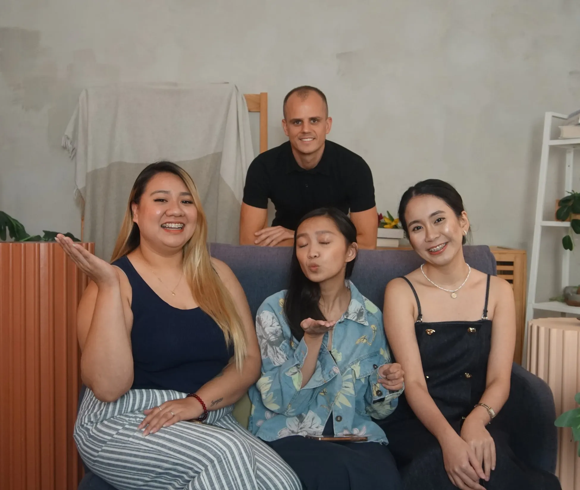 Group photo of four people sitting together casually - appears to be a family or team photo