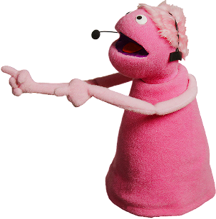 Pink puppet with headset pointing left with both hands and open mouth.