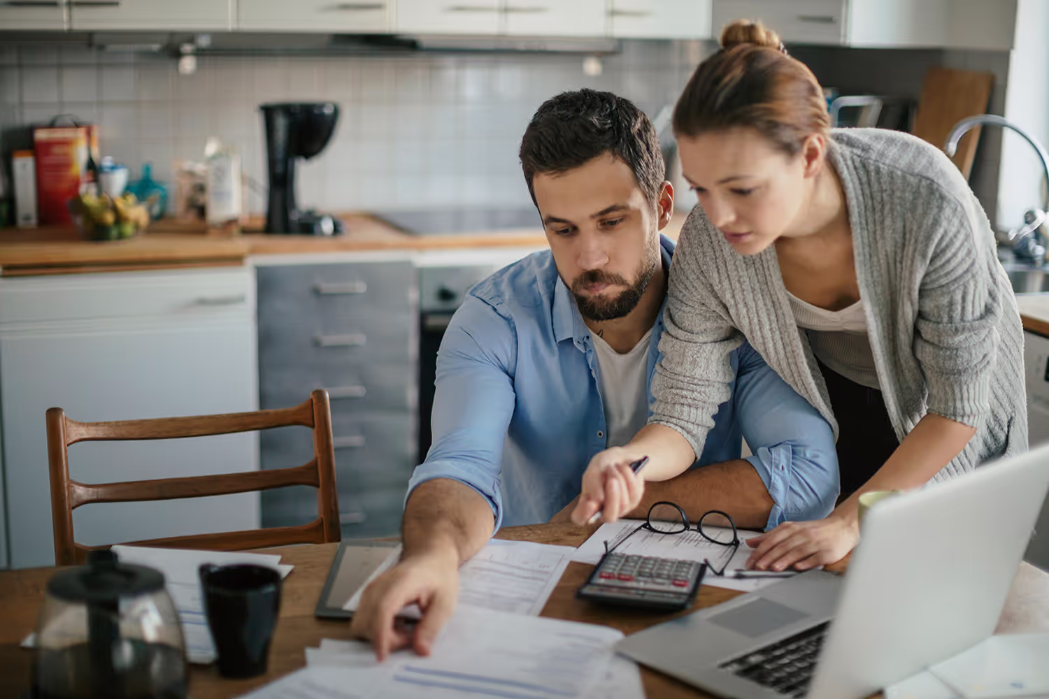 Couple looking at paperwork on kitchen table