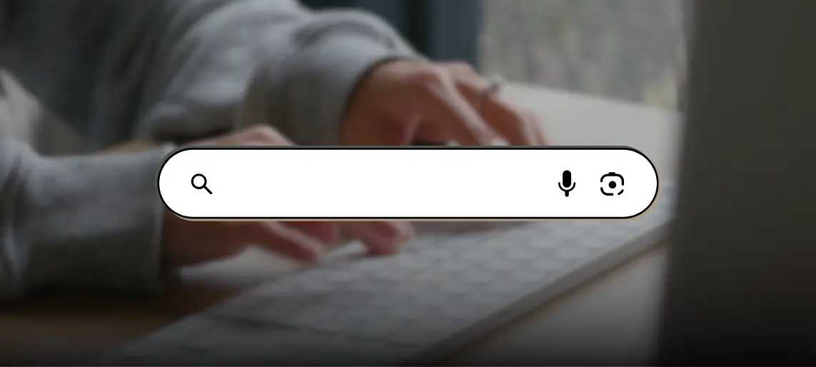 Person typing on keyboard with a digital search bar overlay.