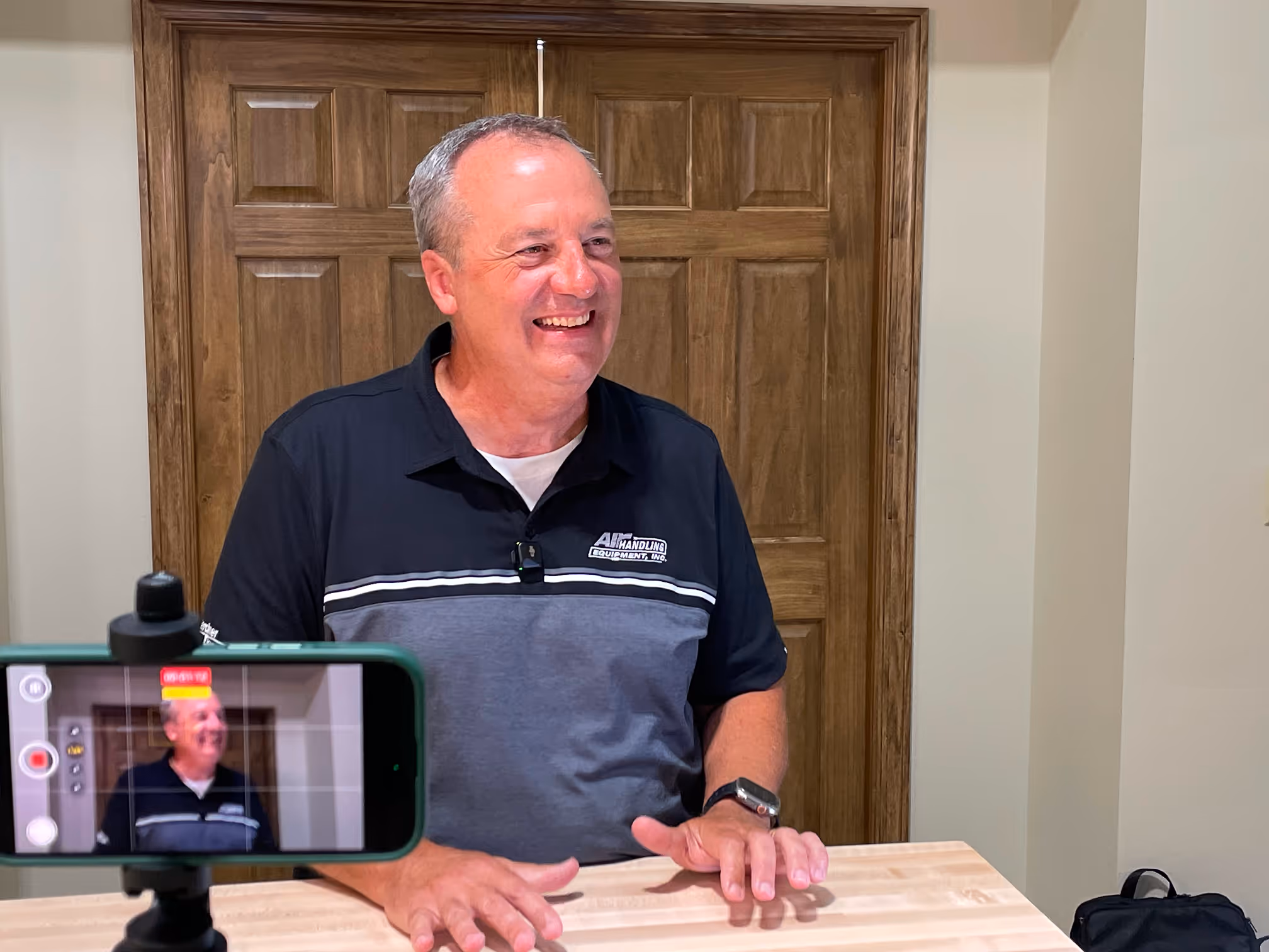 Man smiling on camera while being filmed