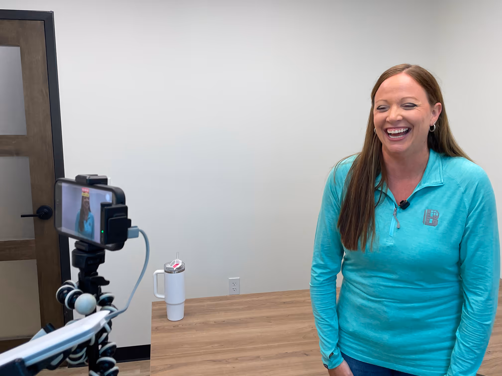 Woman smiling on camera while being filmed