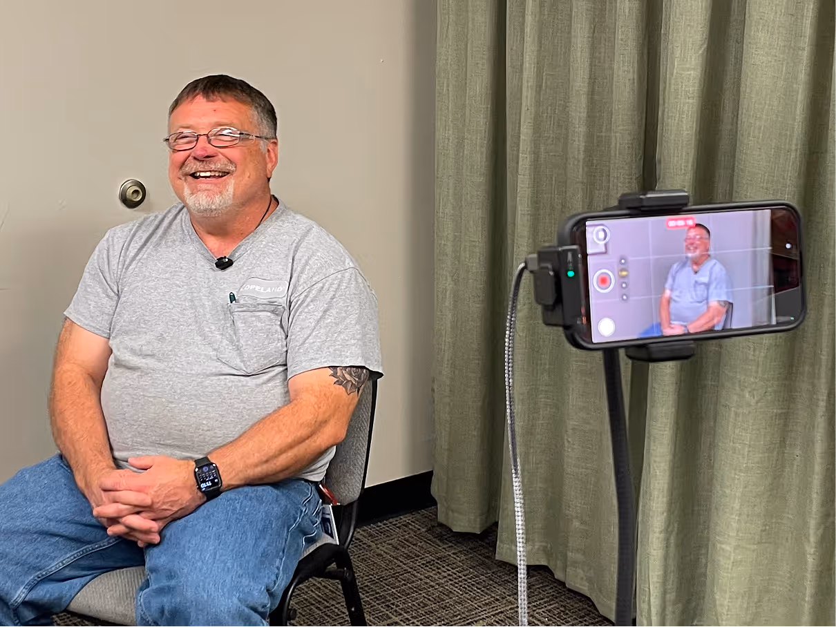 Man smiling on camera while being filmed