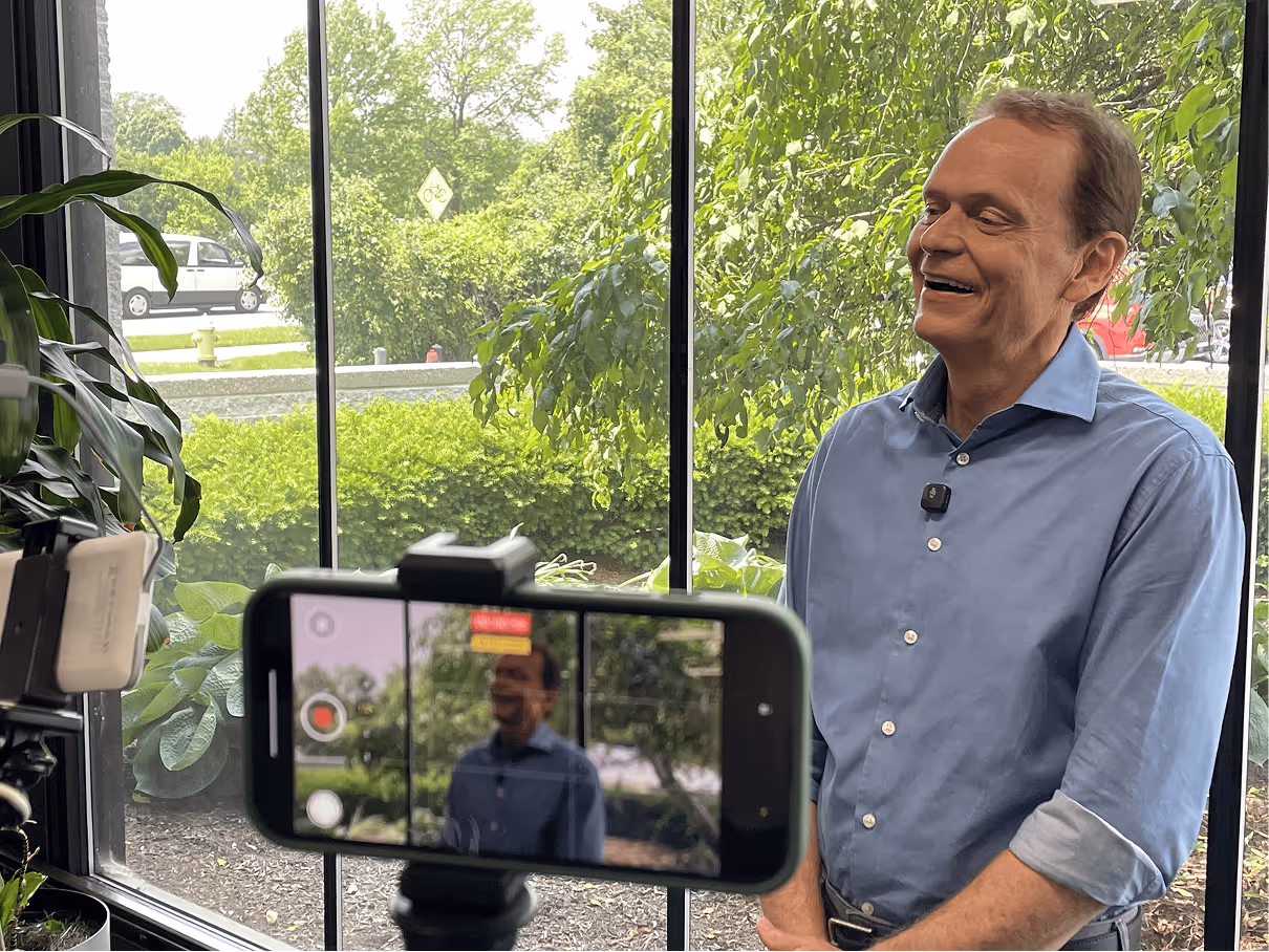 Man smiling on camera while being filmed