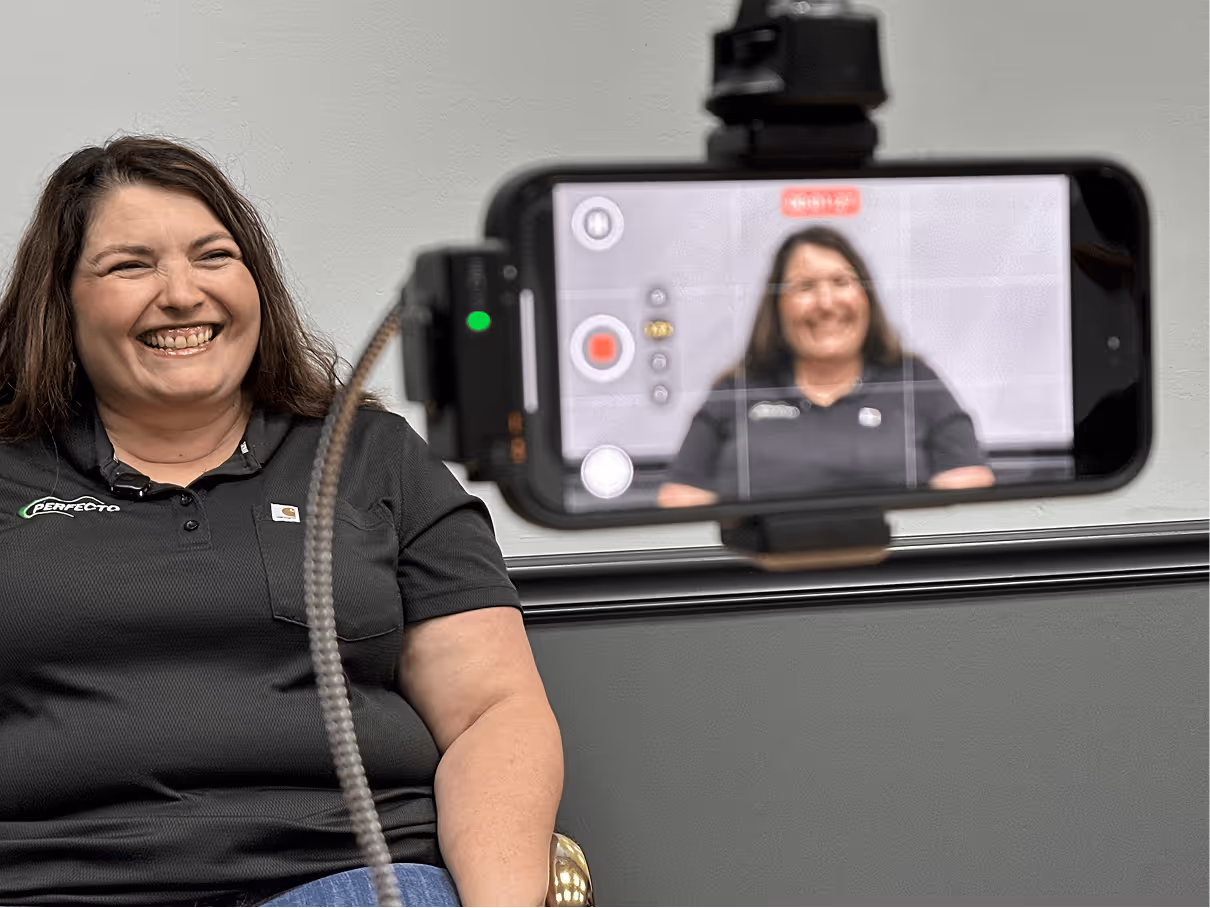 Woman smiling on camera while being filmed
