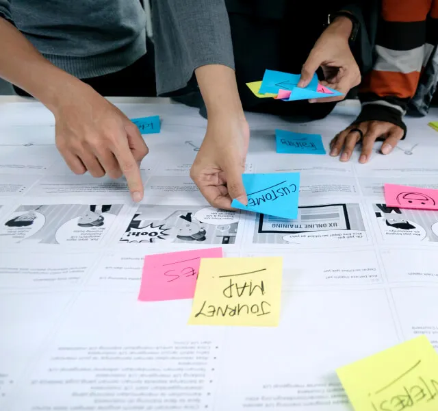 a group of people putting sticky notes on top of a table