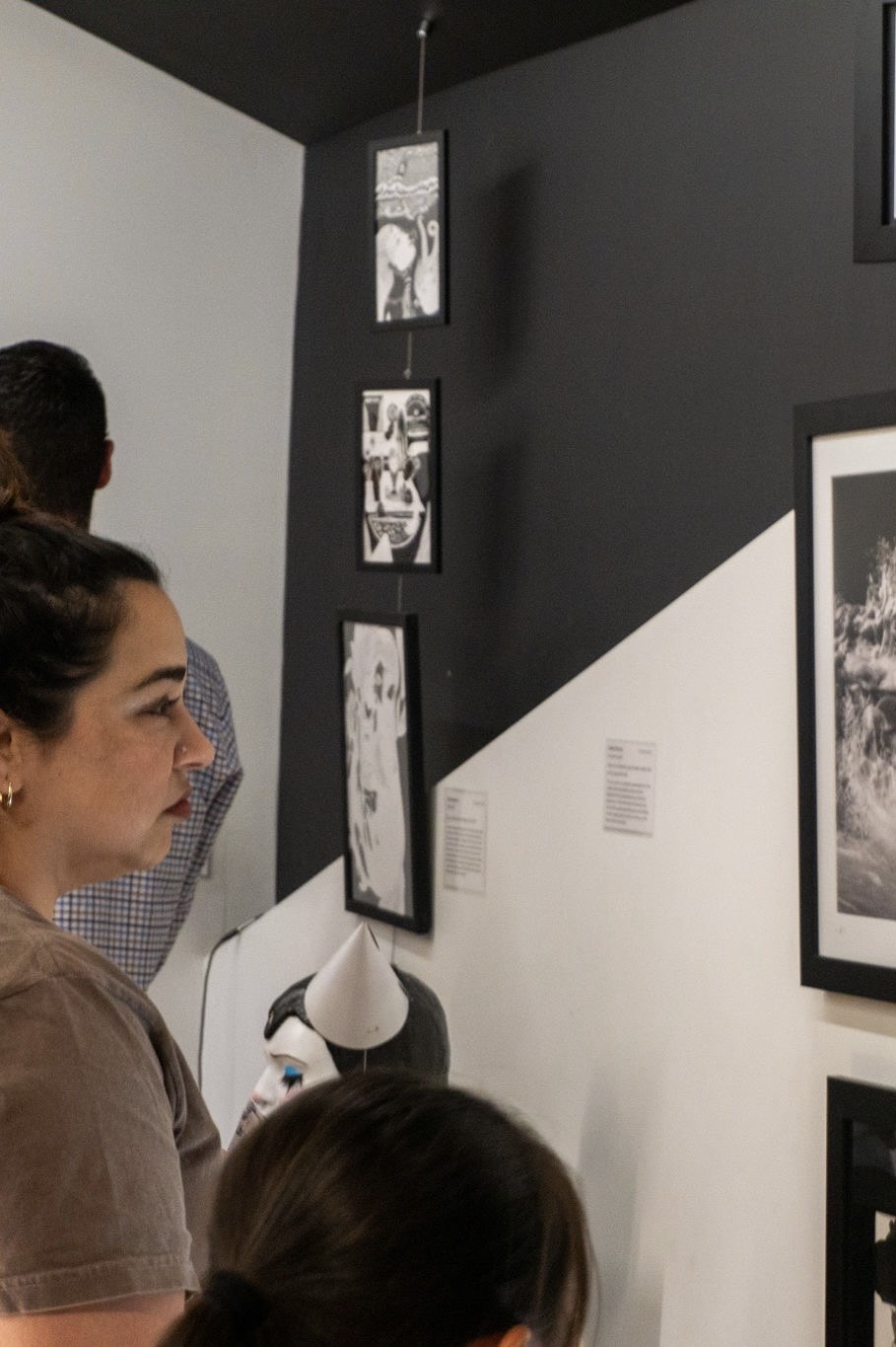 Guest reflecting on an art piece at "Unraveling the Soul" Exhibition