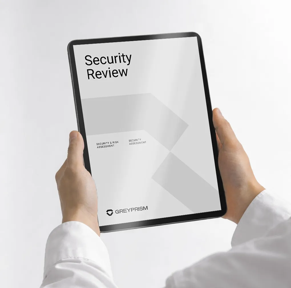 Four people seated around a conference table in a glass-walled office with large windows overlooking a cityscape.