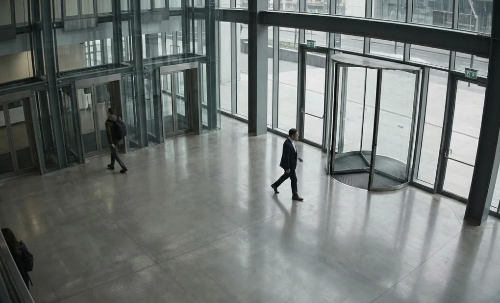 Crowd at a concert with raised hands and bright stage lights illuminating the performers.