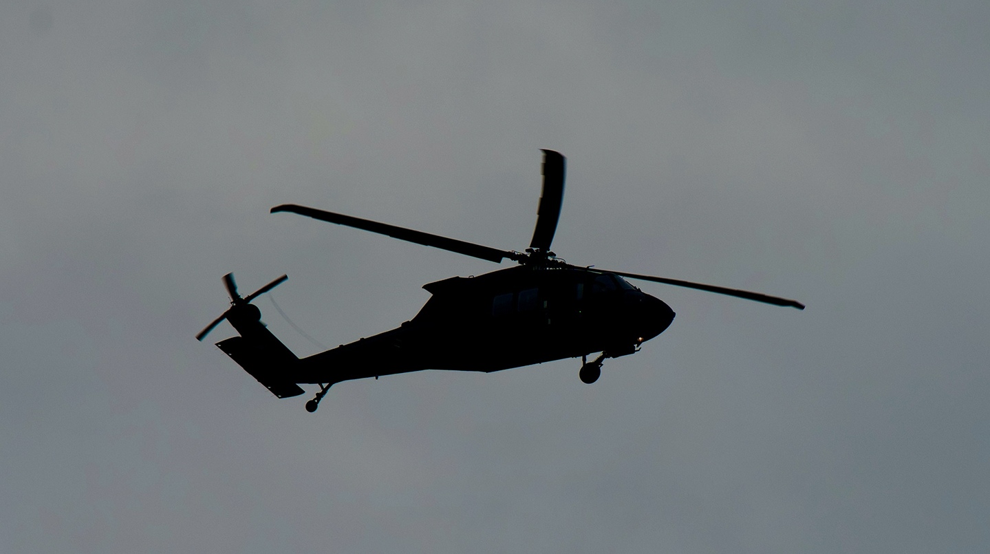 Crowd at a concert with raised hands and bright stage lights illuminating the performers.