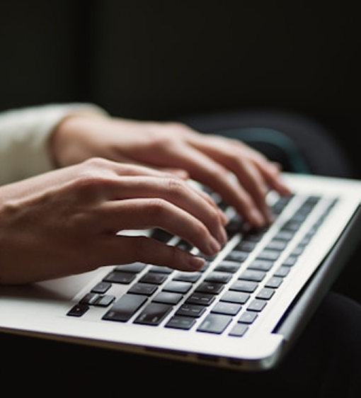 Four people seated around a conference table in a glass-walled office with large windows overlooking a cityscape.
