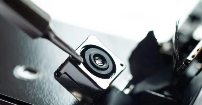 Four people seated around a conference table in a glass-walled office with large windows overlooking a cityscape.