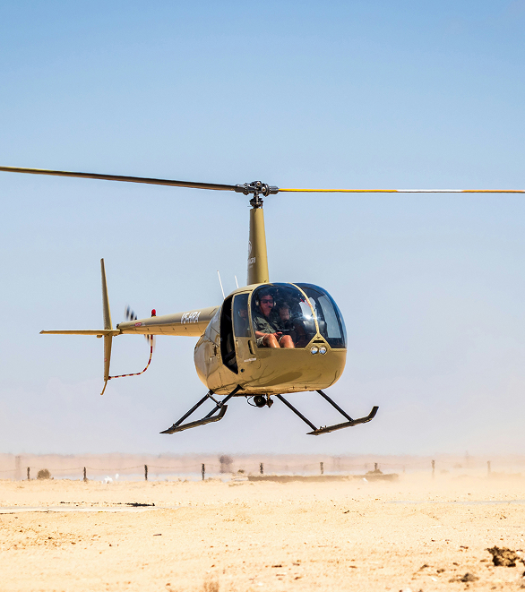 Blurred silhouette of a businessperson walking and talking on a phone beside a tiled urban building.