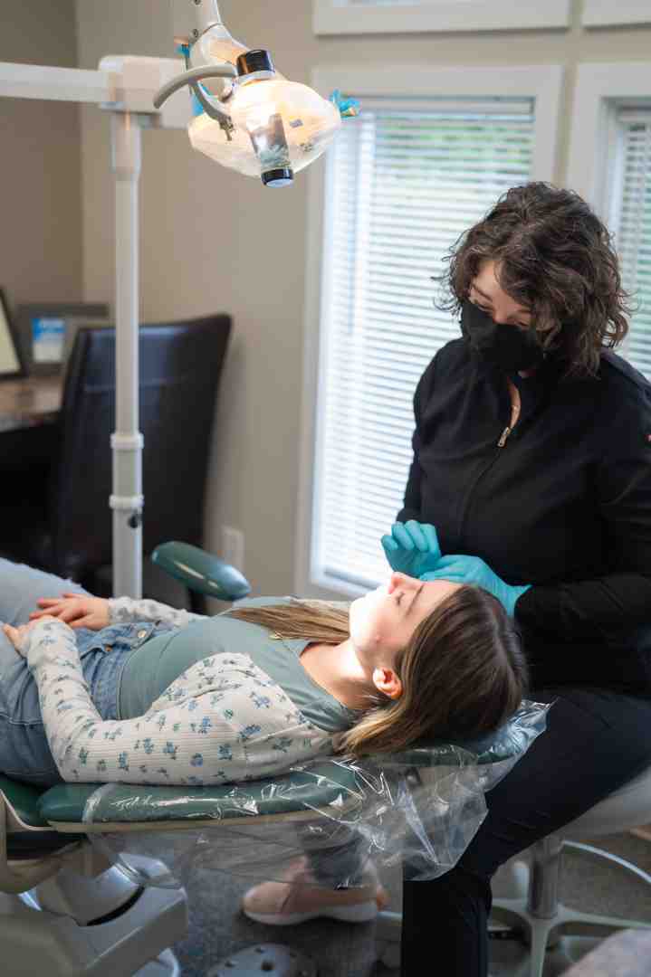 Image of a dentist sculpting a composite veneer on a patient's tooth - Composite Veneers