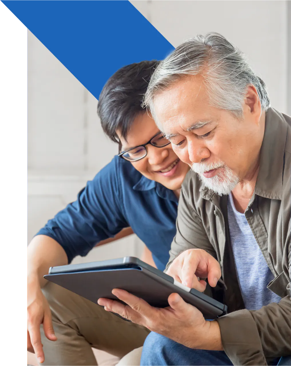 A man and his son using a tablet to look at GreenShield's Pharmacy online.