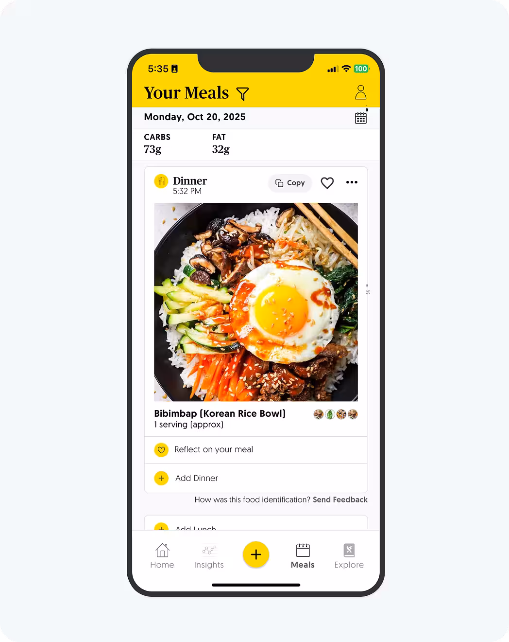 A smartphone displaying a food tracking app with "Your Meals" at the top. The screen shows a "Bibimbap (Korean Rice Bowl)" entry with a photo of the dish, listing 73g carbs and 32g fat for the day.