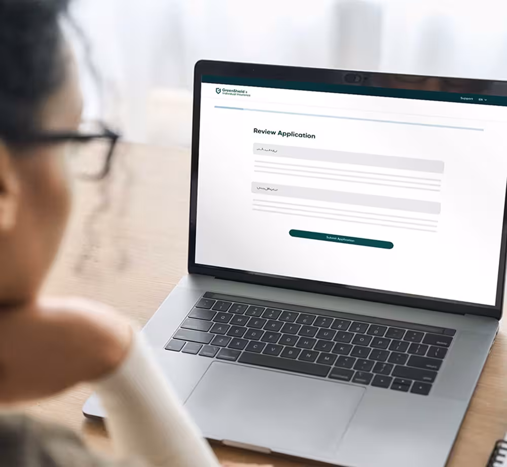 A woman using a laptop to apply for insurance on GreenShield.com