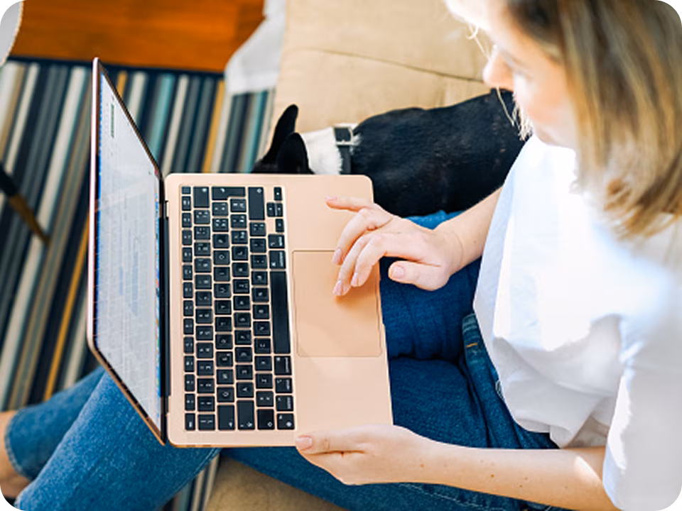 Vue en plongée d’une femme dans sa maison utilisant un ordinateur portable pour amorcer une TCC en ligne, illustrant à quel point il est facile de commencer une thérapie cognitivo‑comportementale en ligne grâce à une plateforme de soutien en santé mentale.