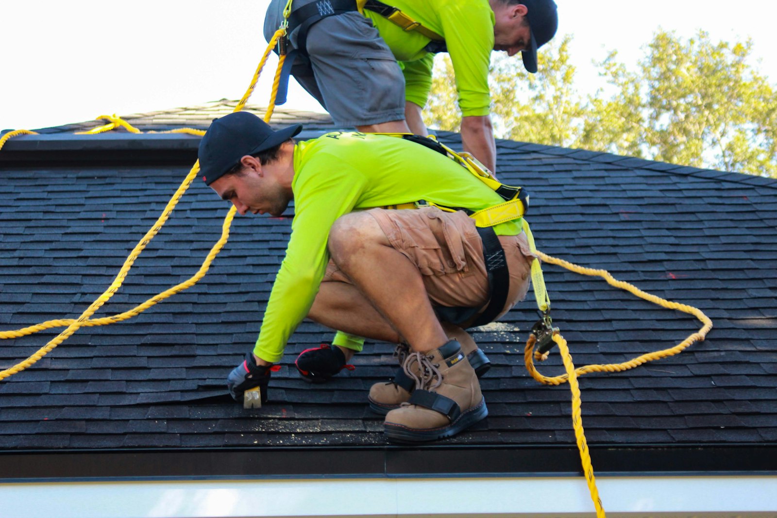 Two roofers working on a house roof in Knoxville