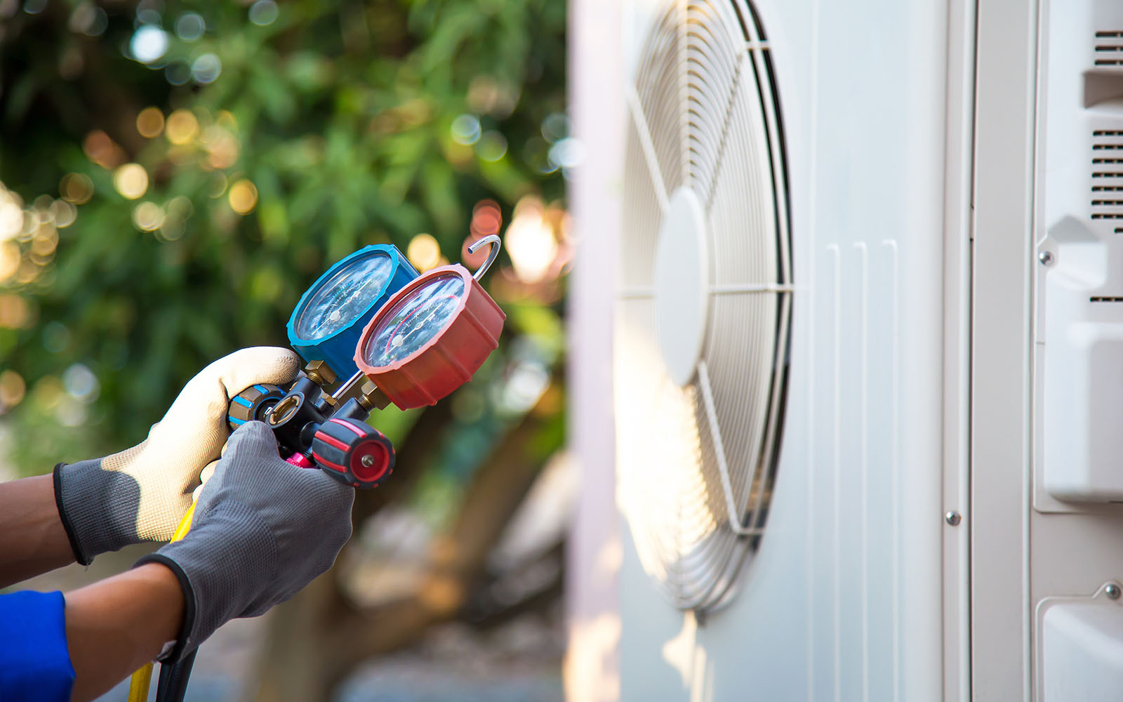HVAC technician checking refrigerant on an outdoor condenser unit at a Maryville, Tennessee home