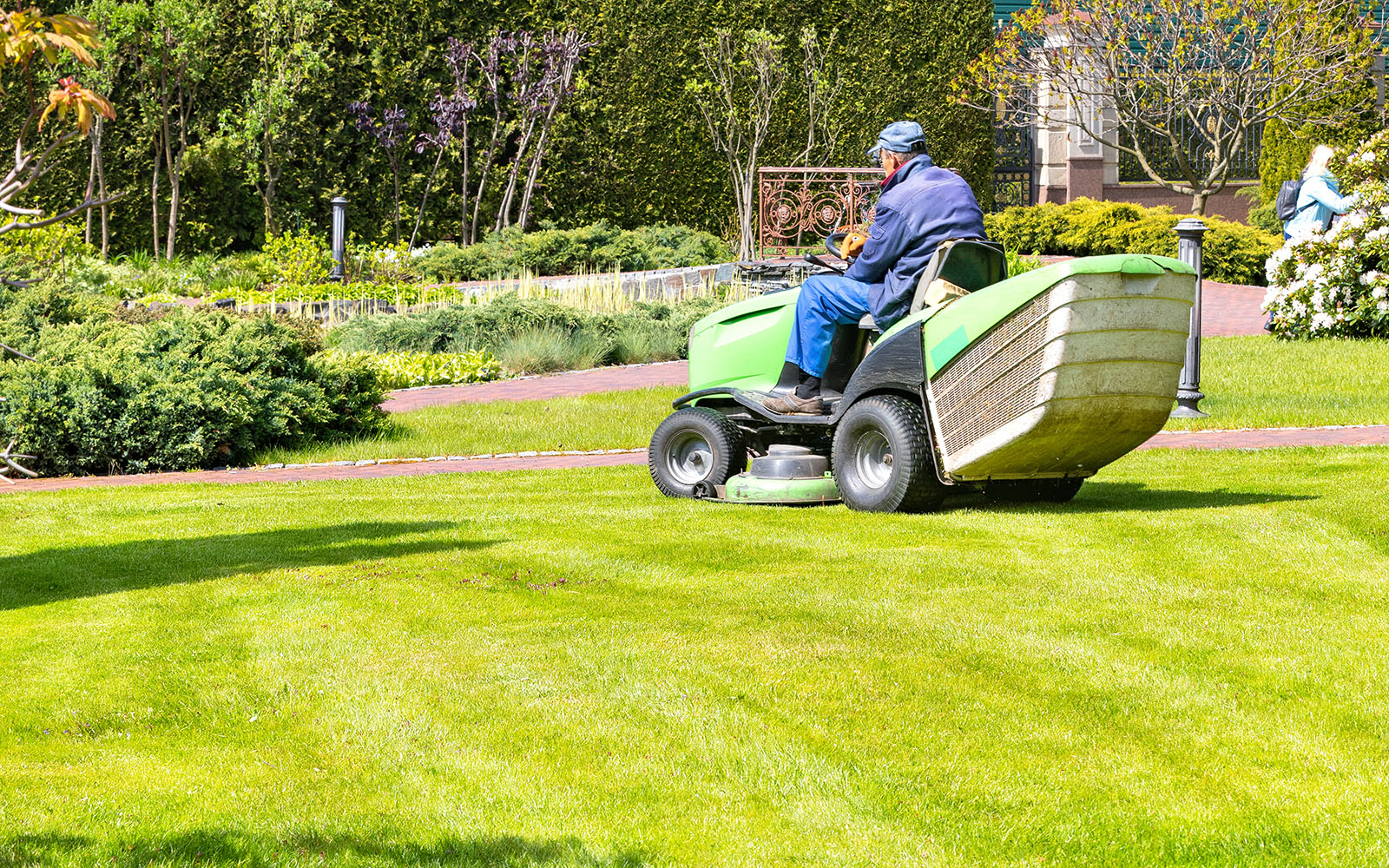 Landscaper mowing a large lawn with a riding mower in Farragut, Tennessee