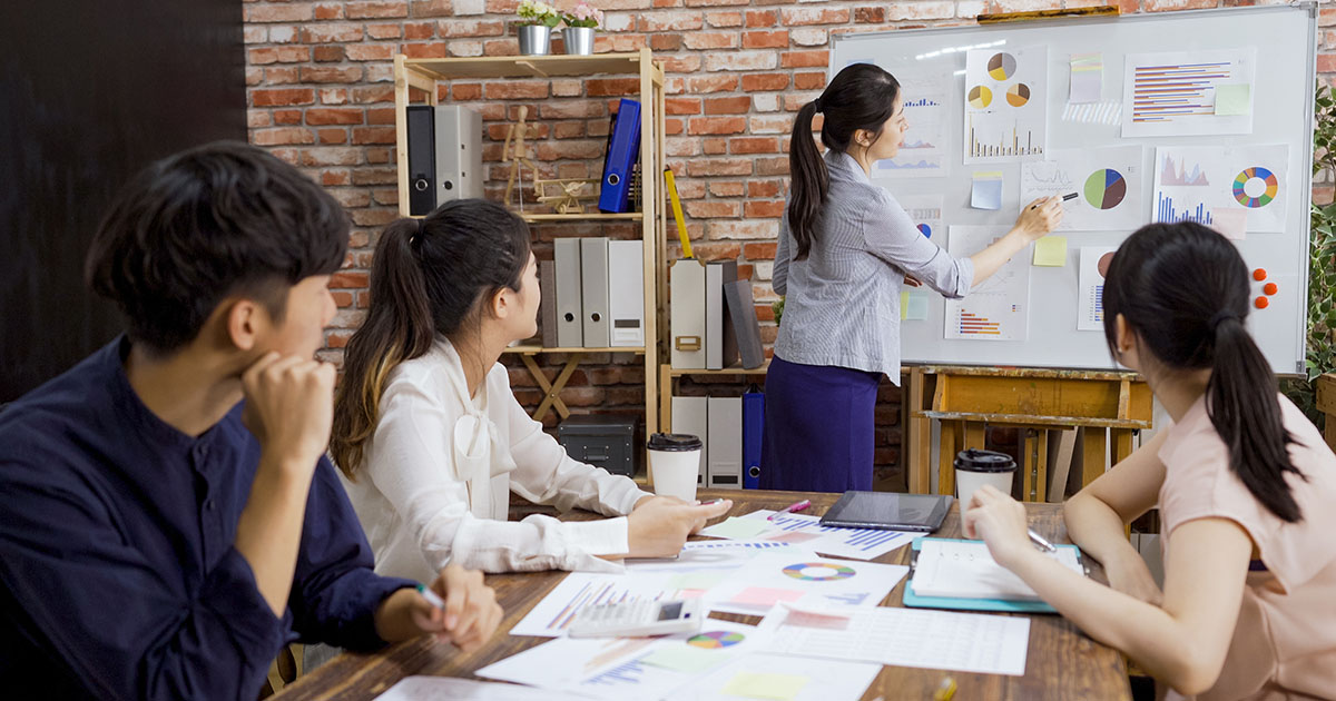 Small marketing team planning a campaign at a whiteboard