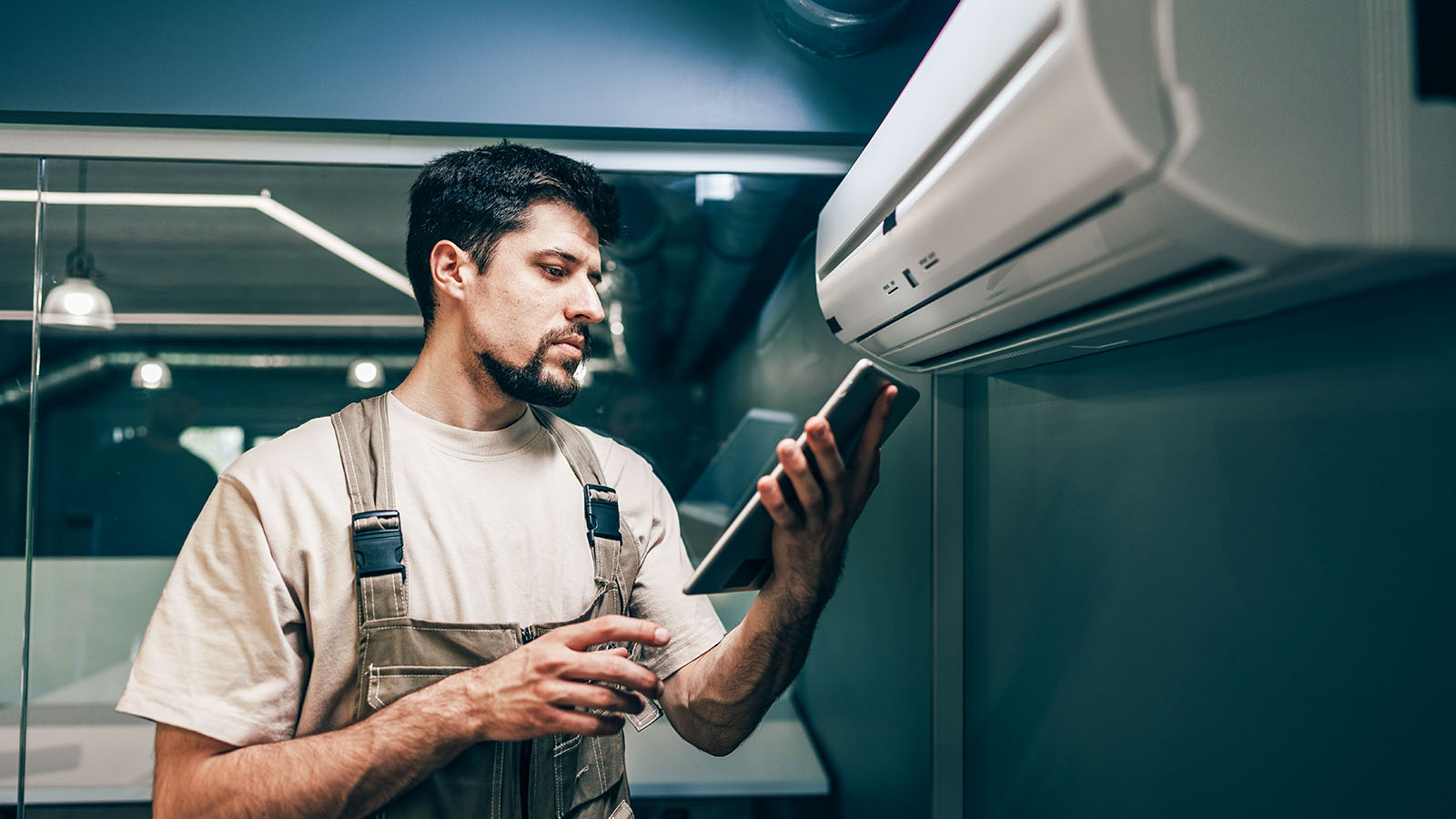 HVAC technician checking service data on a tablet during a home service call in East Tennessee