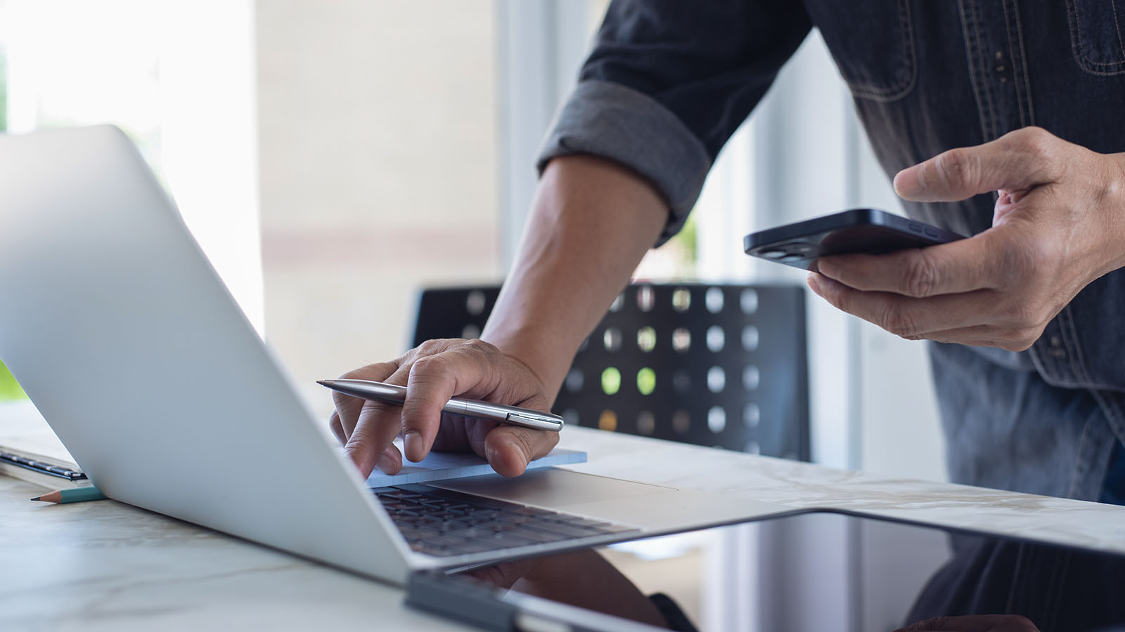 Home services business owner reviewing lead follow-up on a laptop and mobile phone