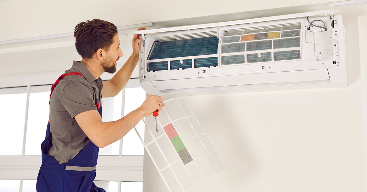 HVAC technician repairing a home air conditioner