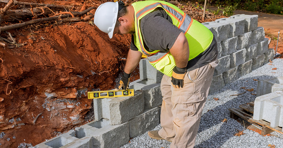 Contractor installing a block retaining wall