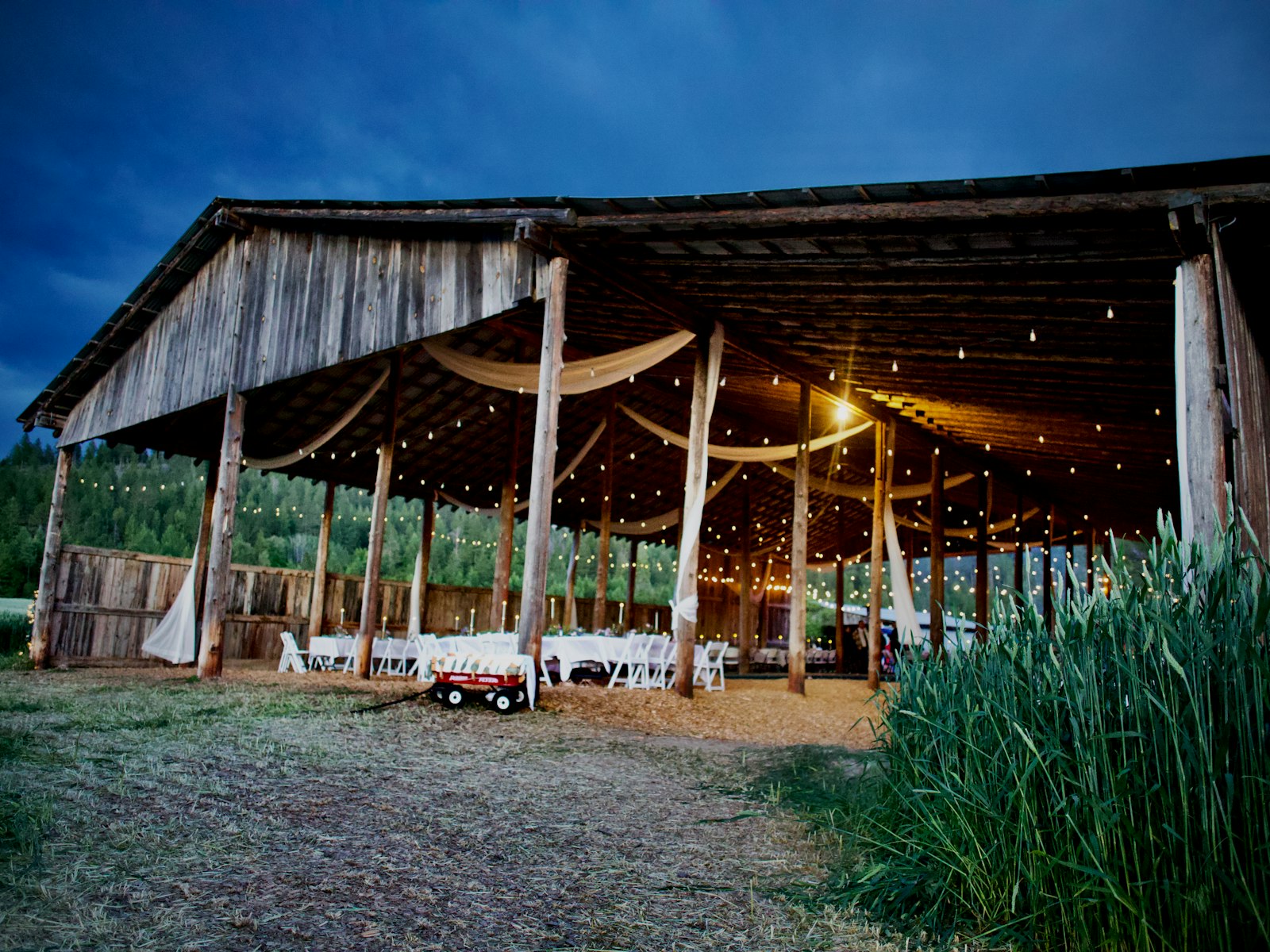 Open-air barn wedding venue with string lights at dusk