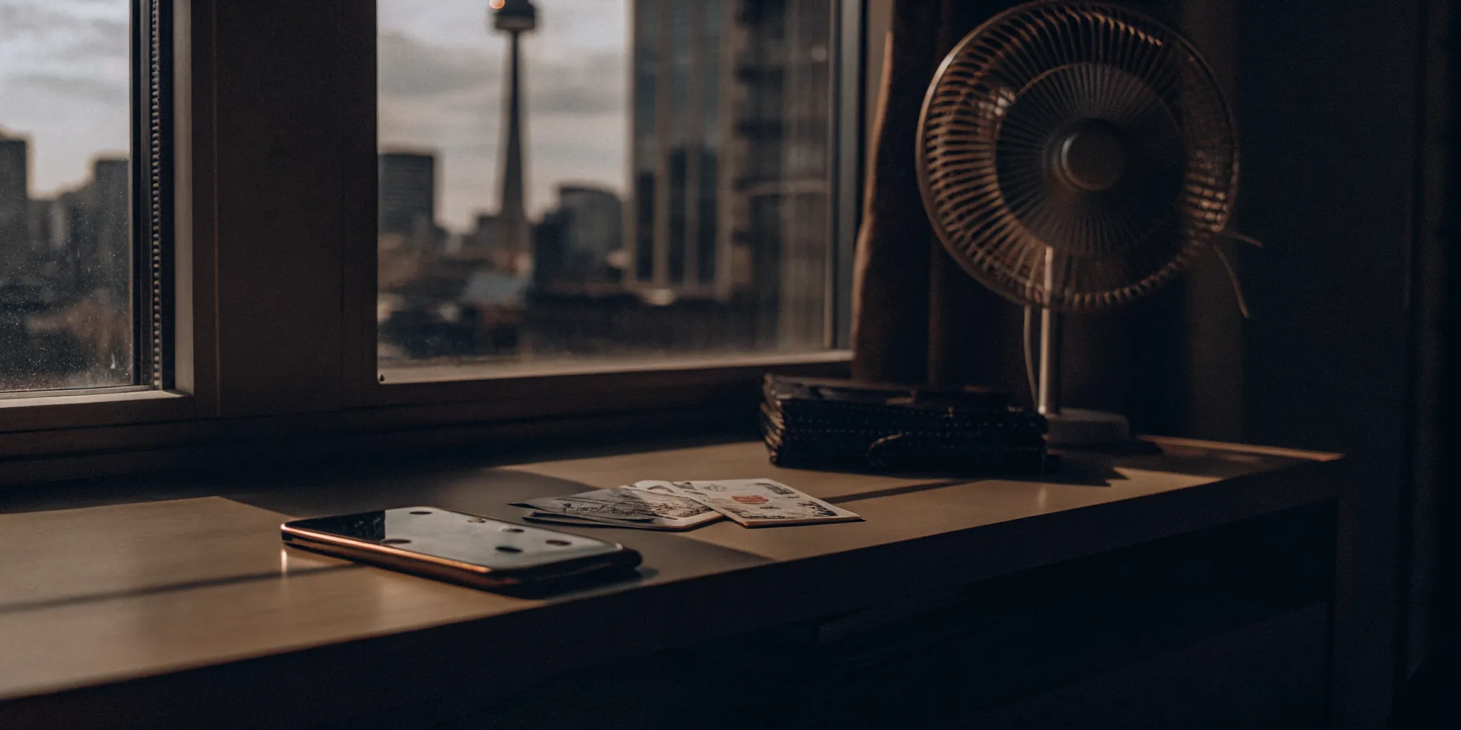 A smartphone, wallet, and Canadian dollar bills on a desk for fast cash in Canada.
