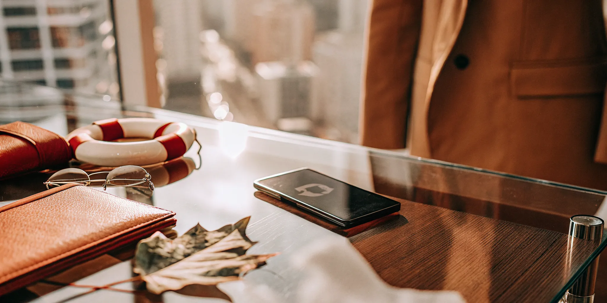 A person's desk with a smartphone and wallet used to find safe emergency loans in Canada.