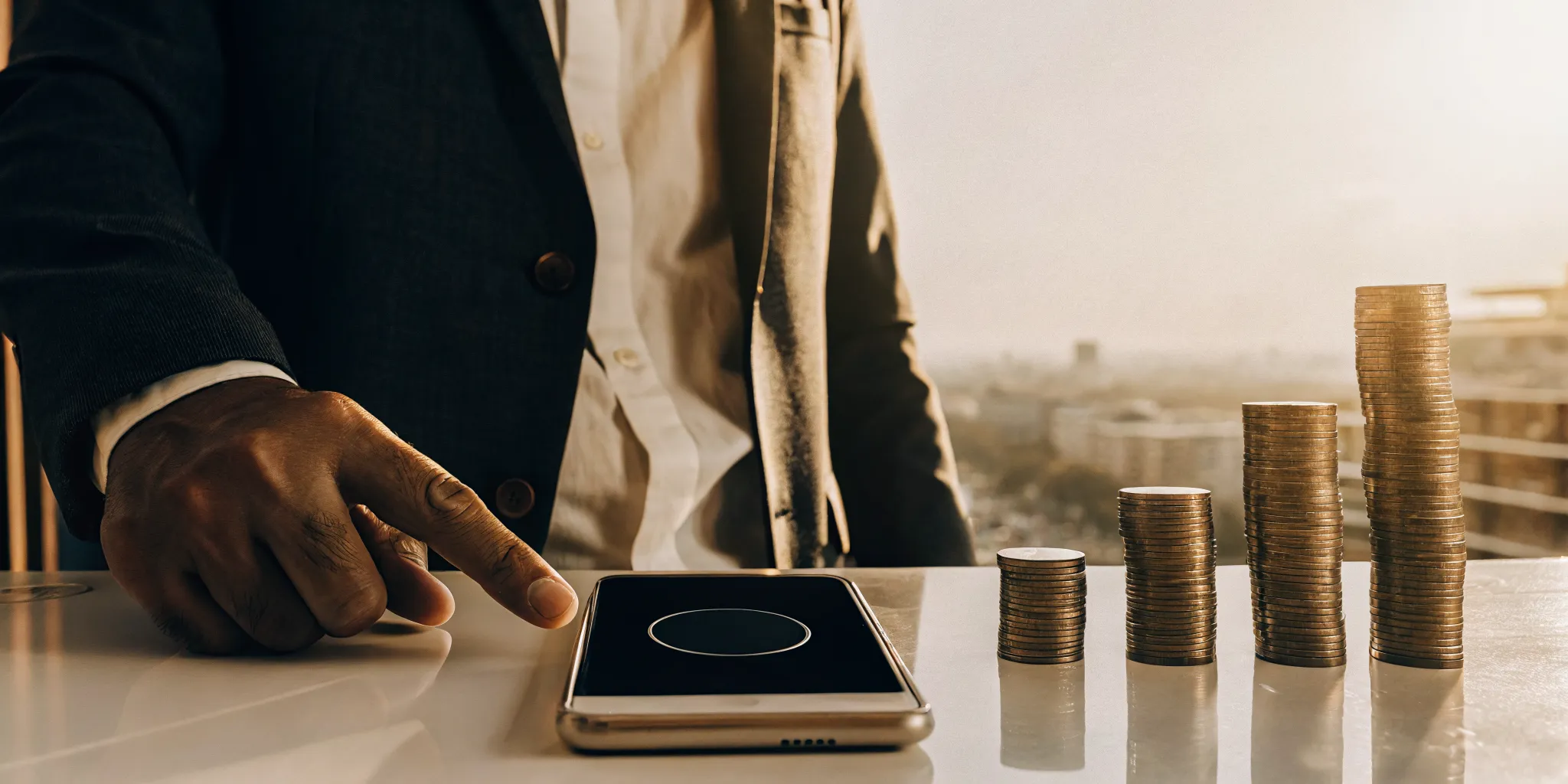 Man with a smartphone and stacked coins calculating how much he can borrow from a payday lender.