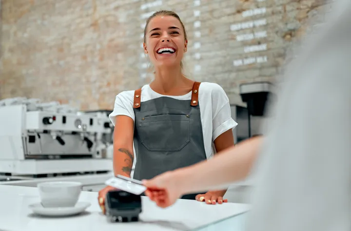 Happy cafe owner after receiving a secured business loan.