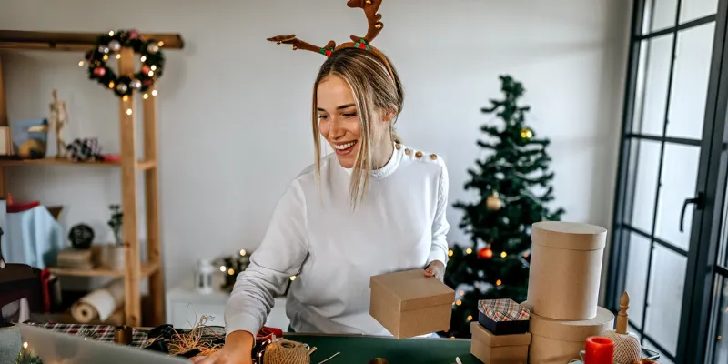 Small business owner reading Bizcap's guide to holiday success while preparing for the new year