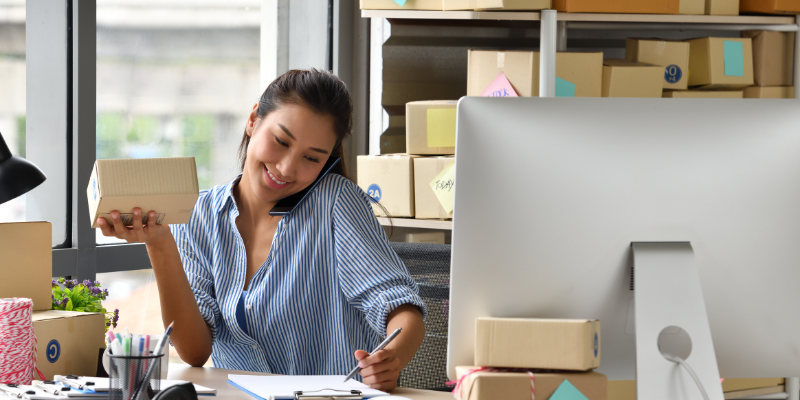 personalised gifts business owner smiling on the phone with client thanks to Bizcap fast funding