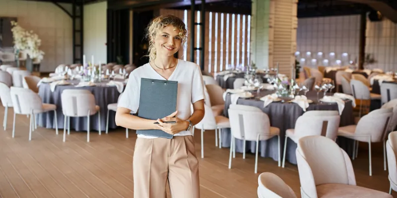 Event management company business owner smiling with a clipboard
