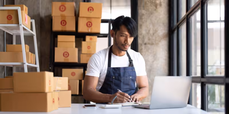 Focused business owner using a laptop to manage cash flow with the help of a Fast Business Loan. 