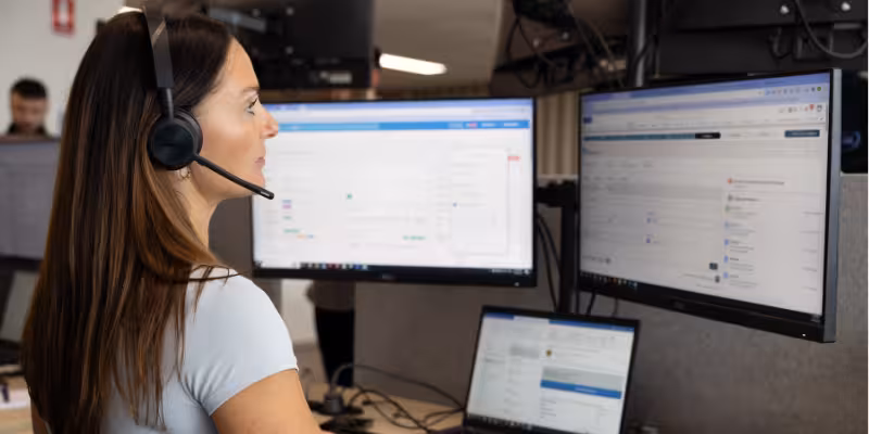 Broker sitting with computer setup on call with small business clients to discuss funding opportunities with Bizcap