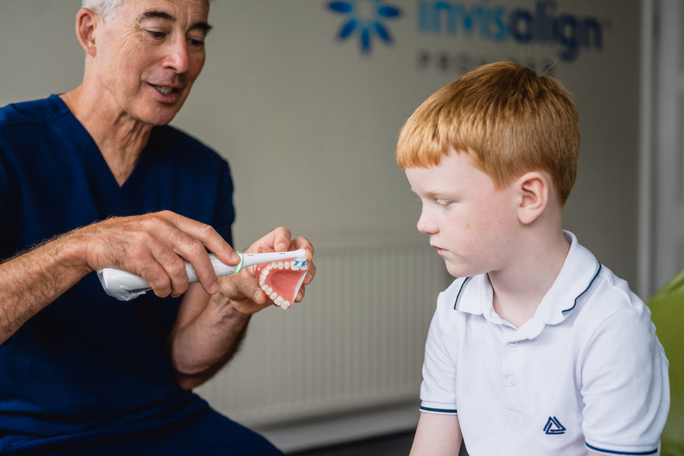 Ed showing child how to brush teeth
