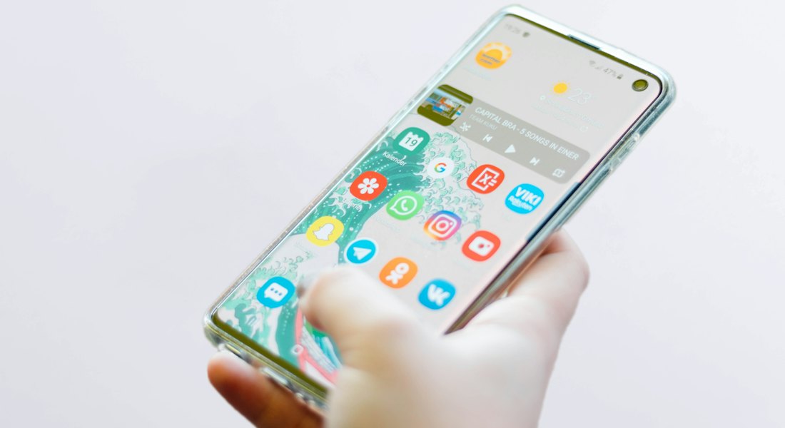 Hand holding a phone with a clean app interface