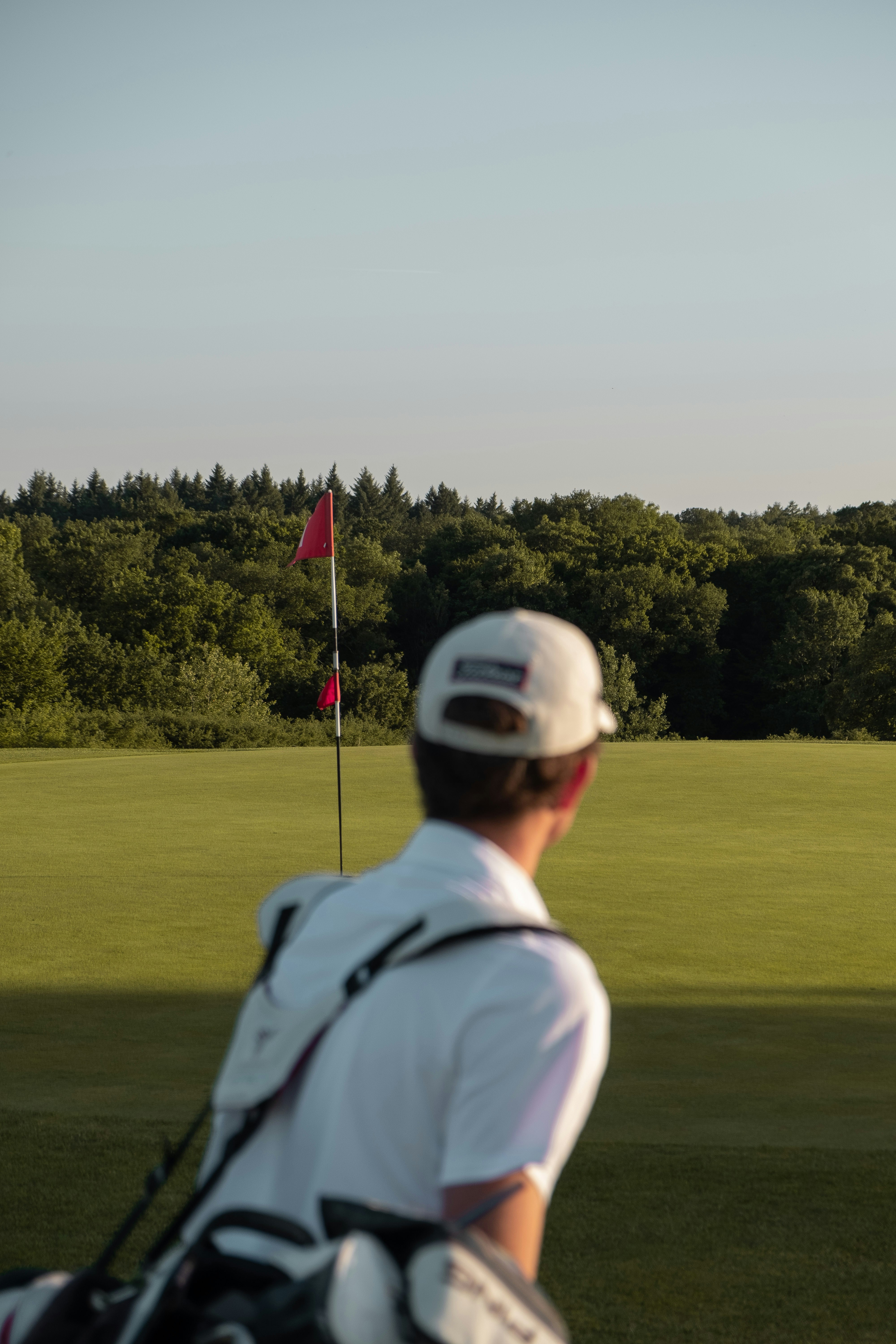 Golfer im Durchschwung mit Blick auf den Ballflug – den Golfschwung über Aufgaben lernen