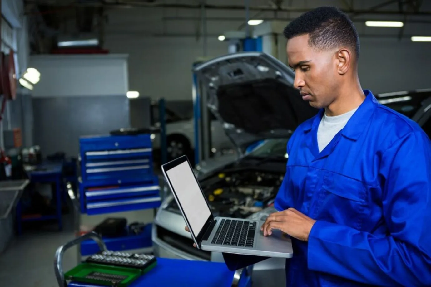 A mechanic utilizing Intelli RMS features like automation, detailed reporting, and real-time monitoring