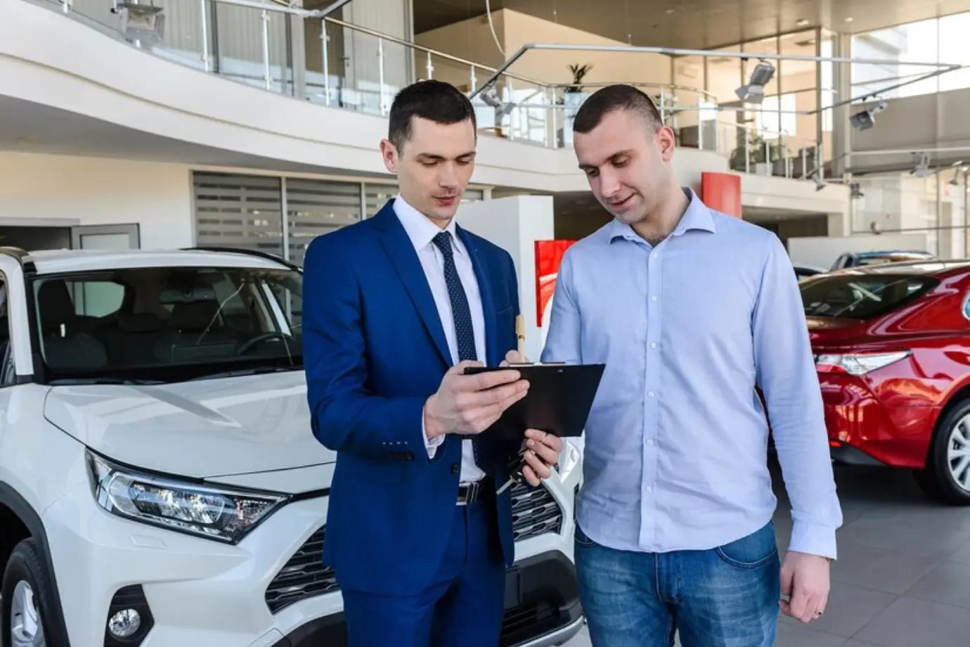 OEM auditor reviewing a dealership showroom, with audit metrics and OEM branding overlaid on the image